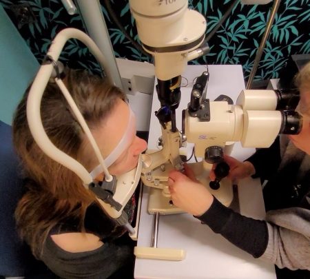 Optometristi tekee asiakkaalle kuivasilmätutkimusta.